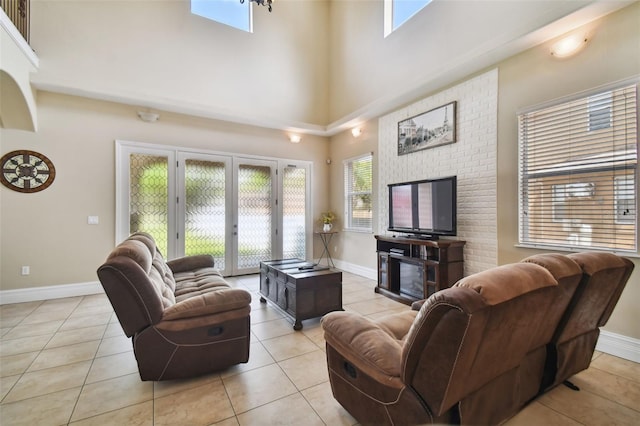 tiled living room featuring french doors, brick wall, and a towering ceiling