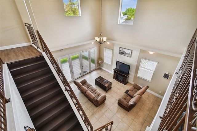 living room with an inviting chandelier, a towering ceiling, and light tile floors