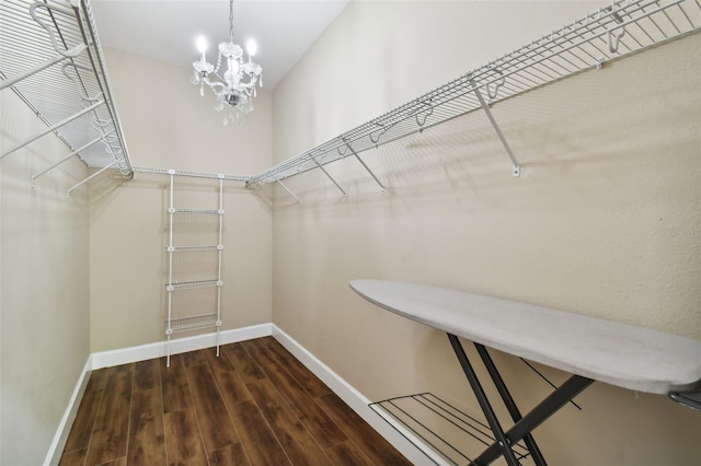 walk in closet featuring a chandelier and dark hardwood / wood-style floors