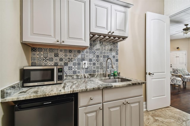 kitchen featuring white cabinets, sink, stainless steel appliances, and light stone countertops