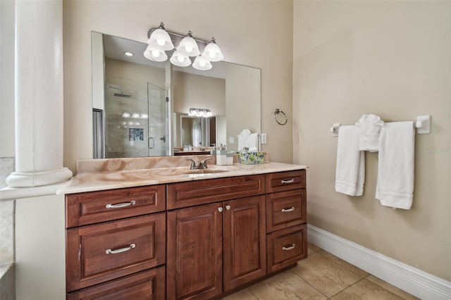 bathroom with tile flooring, vanity, ornate columns, and a shower with shower door