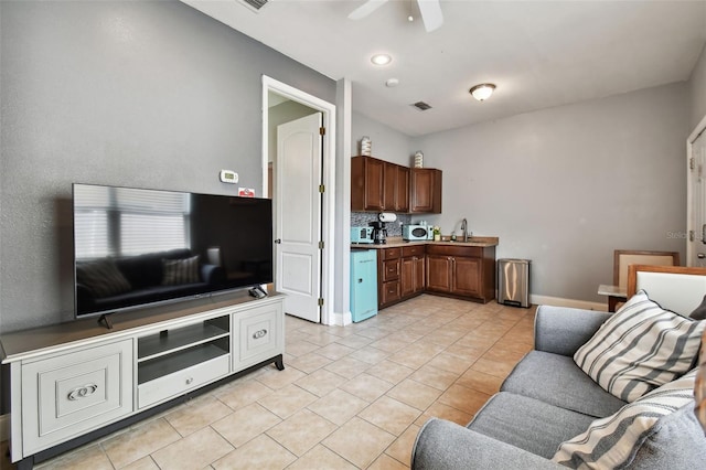 tiled living room featuring sink and ceiling fan