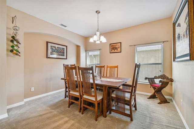 dining room featuring an inviting chandelier and light carpet