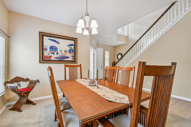 carpeted dining room featuring a notable chandelier