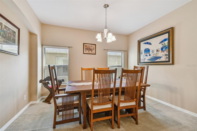 carpeted dining area featuring a chandelier