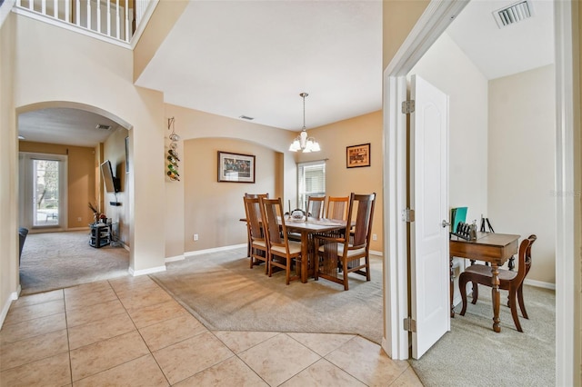 carpeted dining room with an inviting chandelier