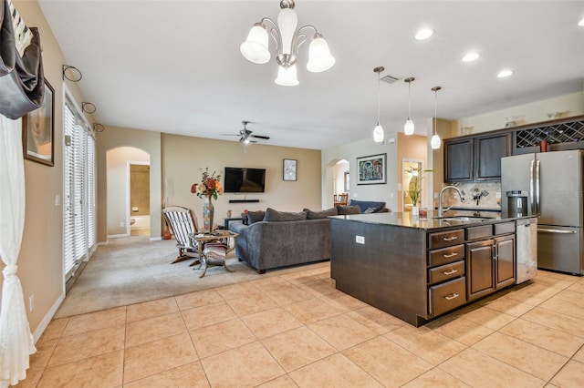 kitchen featuring dark brown cabinetry, pendant lighting, backsplash, ceiling fan with notable chandelier, and stainless steel refrigerator with ice dispenser