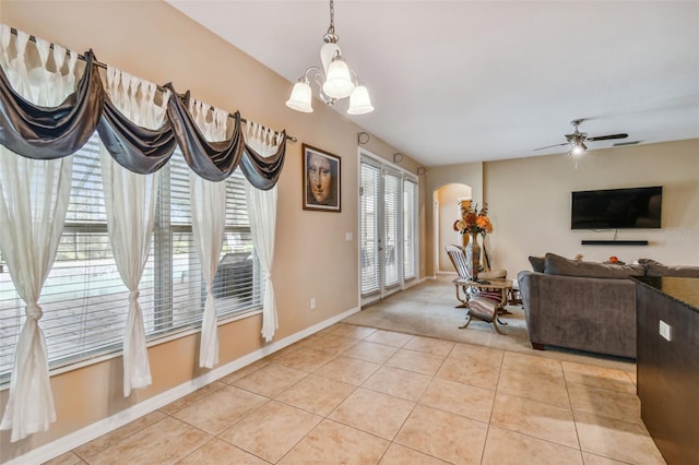 interior space with ceiling fan with notable chandelier and light tile floors