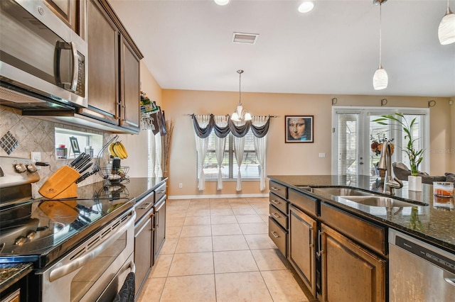 kitchen featuring plenty of natural light, stainless steel appliances, tasteful backsplash, and light tile floors