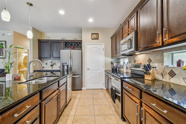 kitchen with stainless steel appliances, backsplash, light tile floors, and decorative light fixtures