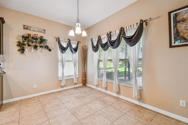 unfurnished room featuring light tile floors and a chandelier