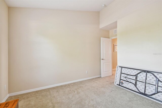 unfurnished room featuring light colored carpet and high vaulted ceiling