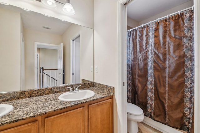 bathroom with double sink vanity and toilet