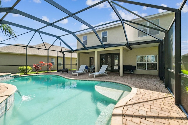 view of swimming pool featuring pool water feature, glass enclosure, and a patio area