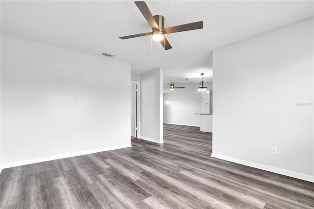 unfurnished room with a textured ceiling, ceiling fan, and dark hardwood / wood-style flooring