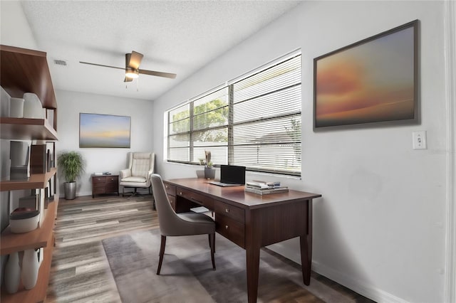 office featuring a textured ceiling, hardwood / wood-style flooring, and ceiling fan