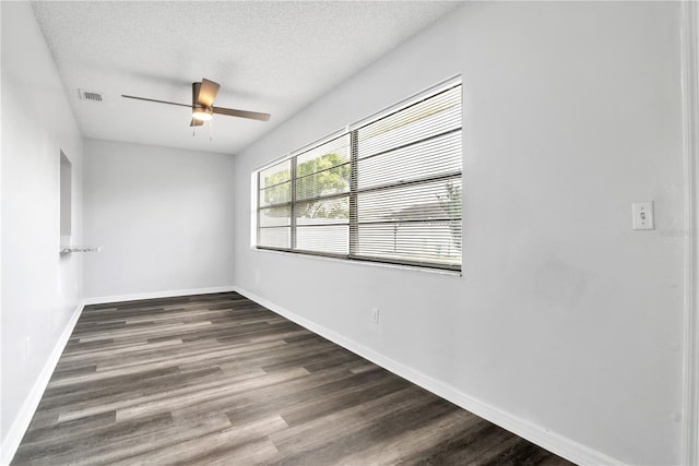 empty room with ceiling fan, a textured ceiling, and dark hardwood / wood-style flooring