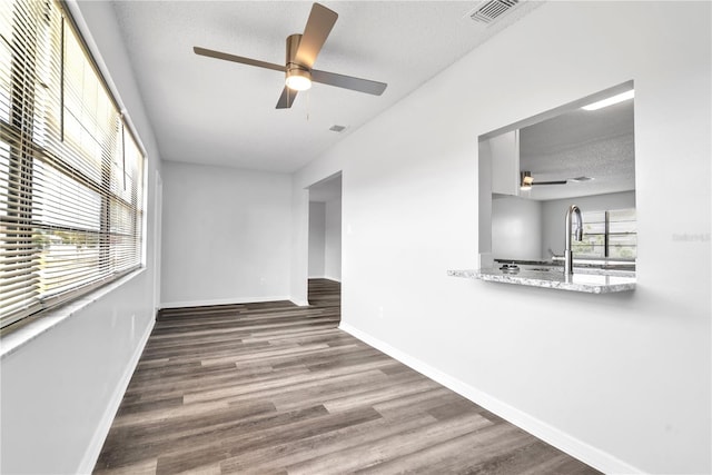 unfurnished room with sink, a textured ceiling, wood-type flooring, and ceiling fan