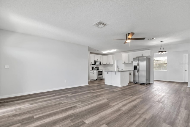 unfurnished living room featuring sink, a textured ceiling, hardwood / wood-style flooring, and ceiling fan with notable chandelier