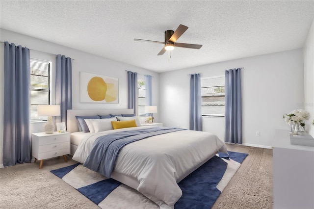 carpeted bedroom featuring a textured ceiling and ceiling fan