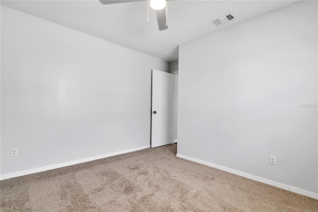 carpeted spare room with ceiling fan and a textured ceiling