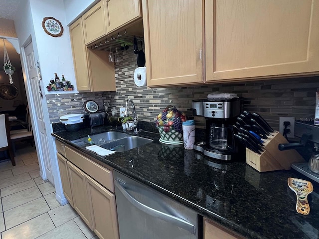 kitchen with dishwasher, tasteful backsplash, dark stone countertops, sink, and light tile floors