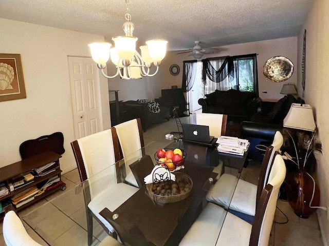 tiled dining room with ceiling fan with notable chandelier and a textured ceiling