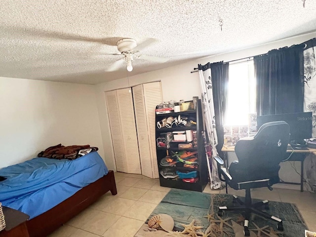 tiled bedroom featuring a closet, ceiling fan, and a textured ceiling