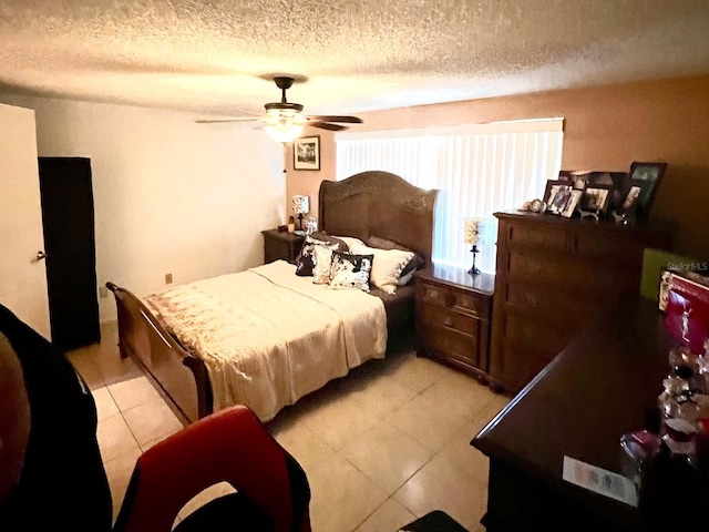 bedroom featuring a textured ceiling, ceiling fan, and light tile flooring