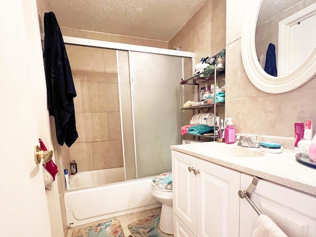 full bathroom with a textured ceiling, toilet, oversized vanity, and combined bath / shower with glass door