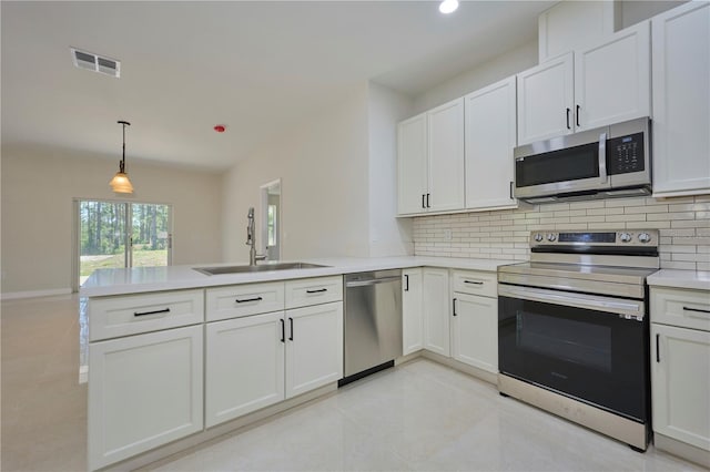 kitchen with appliances with stainless steel finishes, light tile floors, white cabinetry, decorative light fixtures, and kitchen peninsula