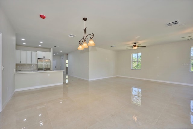 unfurnished living room featuring sink, ceiling fan, and light tile floors