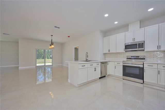 kitchen featuring appliances with stainless steel finishes, sink, light tile flooring, white cabinetry, and pendant lighting