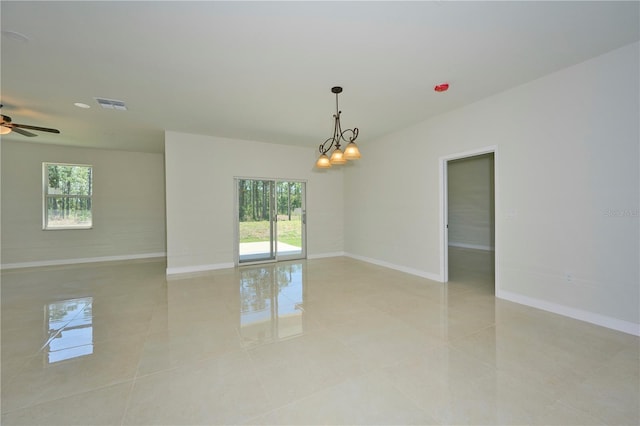 unfurnished room with ceiling fan with notable chandelier and light tile floors