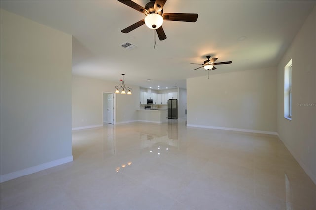 tiled spare room with ceiling fan with notable chandelier