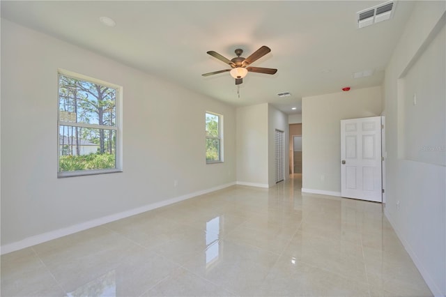 empty room with ceiling fan and light tile floors