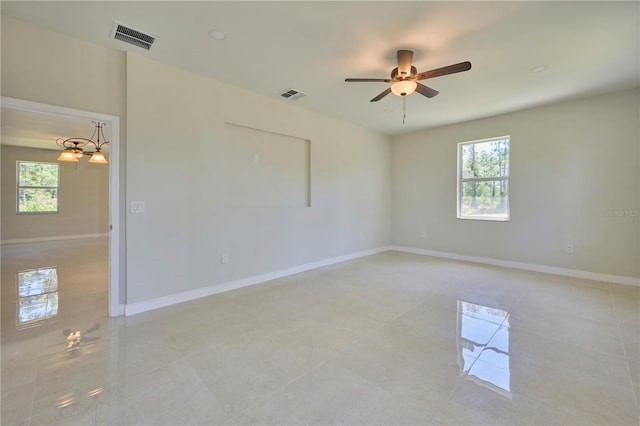 tiled empty room with a wealth of natural light and ceiling fan