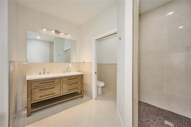 bathroom with tile walls, dual vanity, tasteful backsplash, toilet, and tile floors