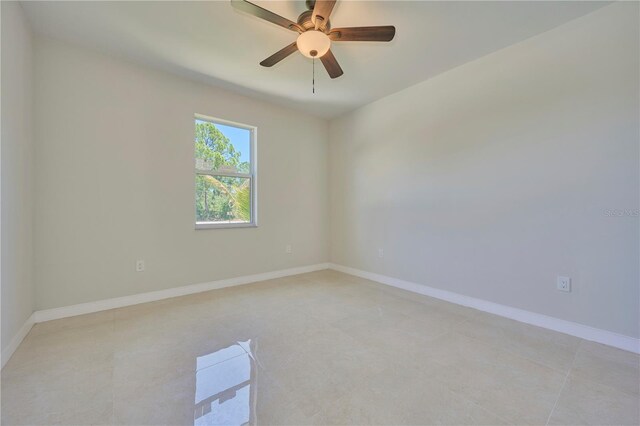 empty room with ceiling fan and light tile flooring