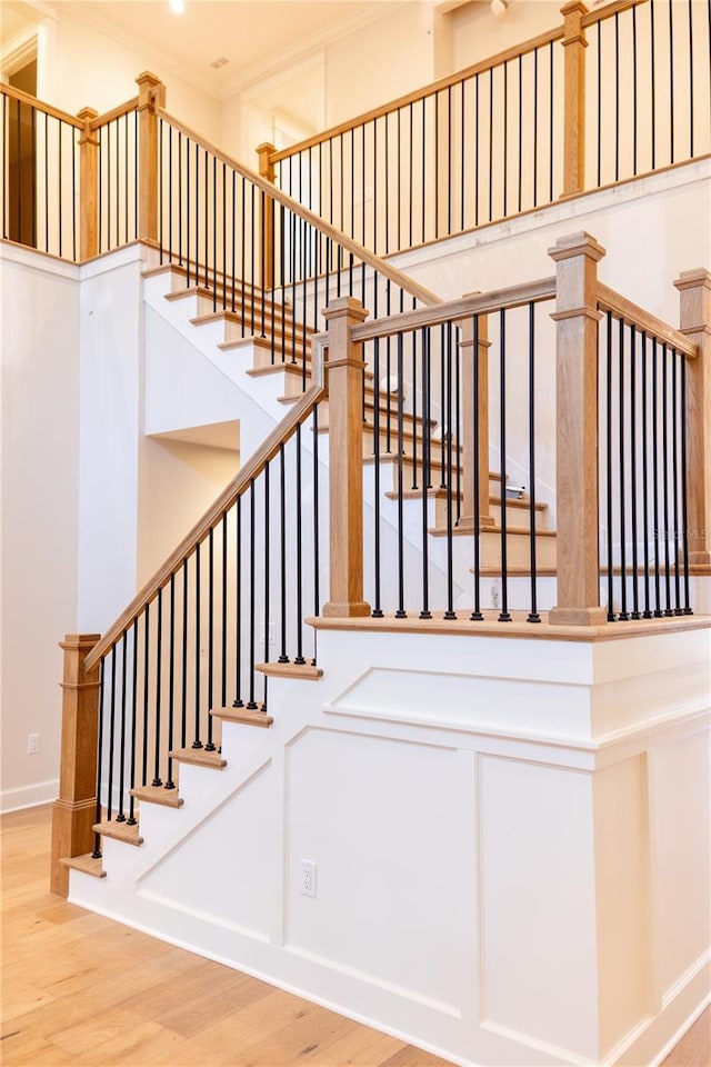 staircase featuring hardwood / wood-style floors and ornamental molding