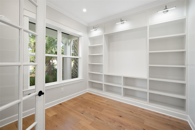 unfurnished room with hardwood / wood-style flooring, crown molding, and built in features