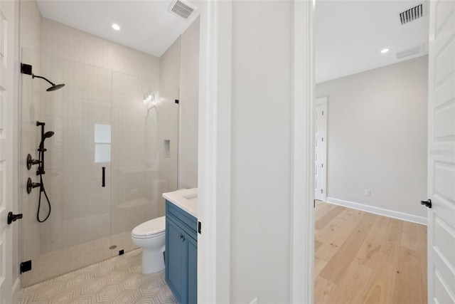 bathroom with hardwood / wood-style flooring, toilet, vanity, and a shower with shower door