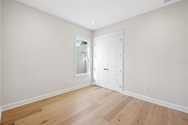 unfurnished bedroom featuring light wood-type flooring and a closet