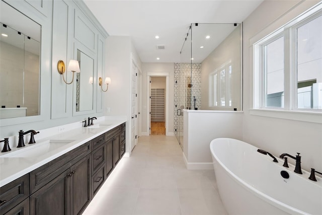 bathroom with tile patterned flooring, vanity, and plus walk in shower
