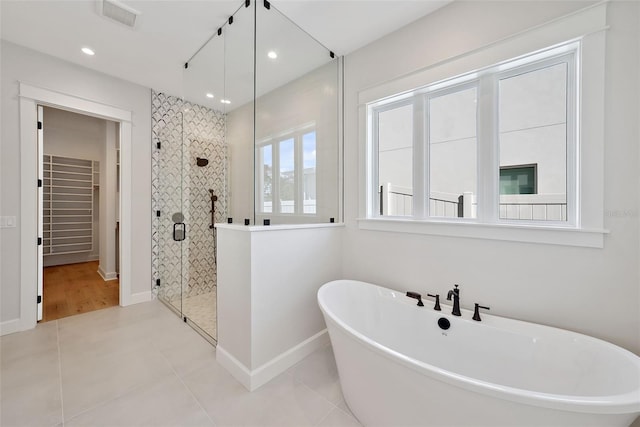 bathroom with tile patterned floors and independent shower and bath