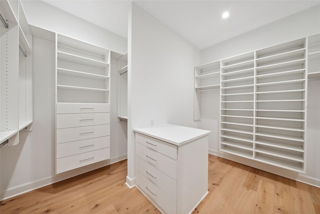 walk in closet with light hardwood / wood-style floors
