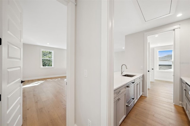 bar with sink and light hardwood / wood-style floors