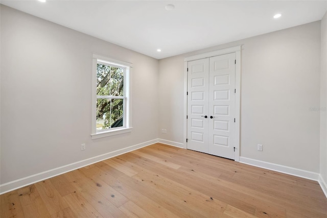 unfurnished bedroom with a closet and light hardwood / wood-style flooring