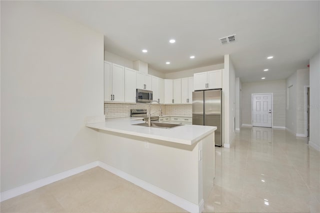 kitchen featuring kitchen peninsula, stainless steel appliances, light tile floors, and sink