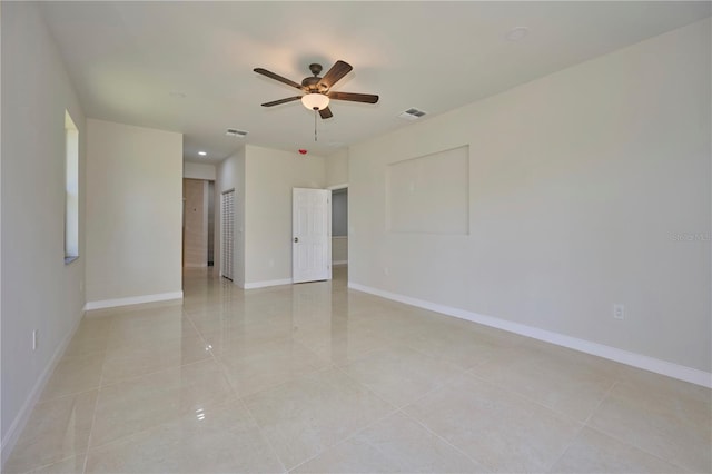 empty room with ceiling fan and light tile floors